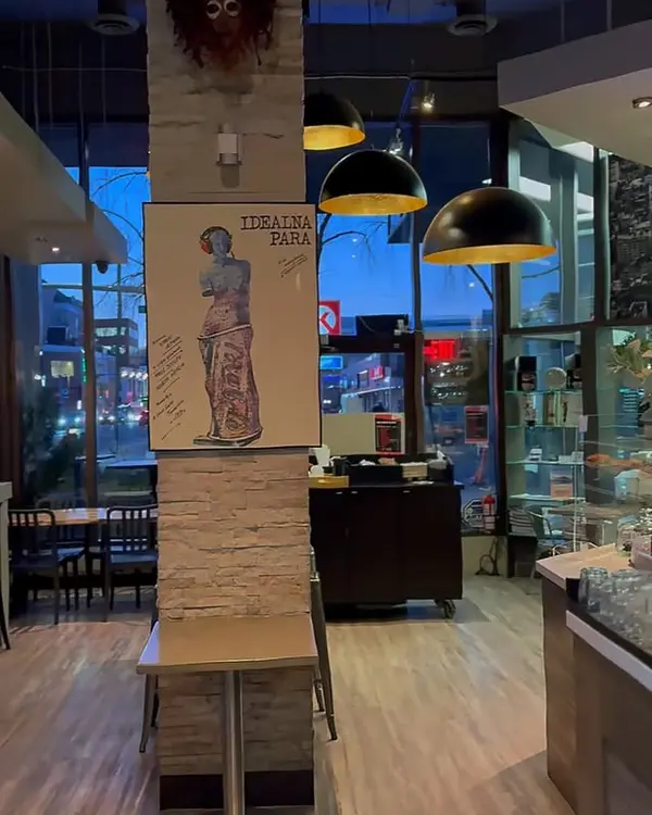 Daytime interior of Kawa Espresso Bar — seating, plants and big windows